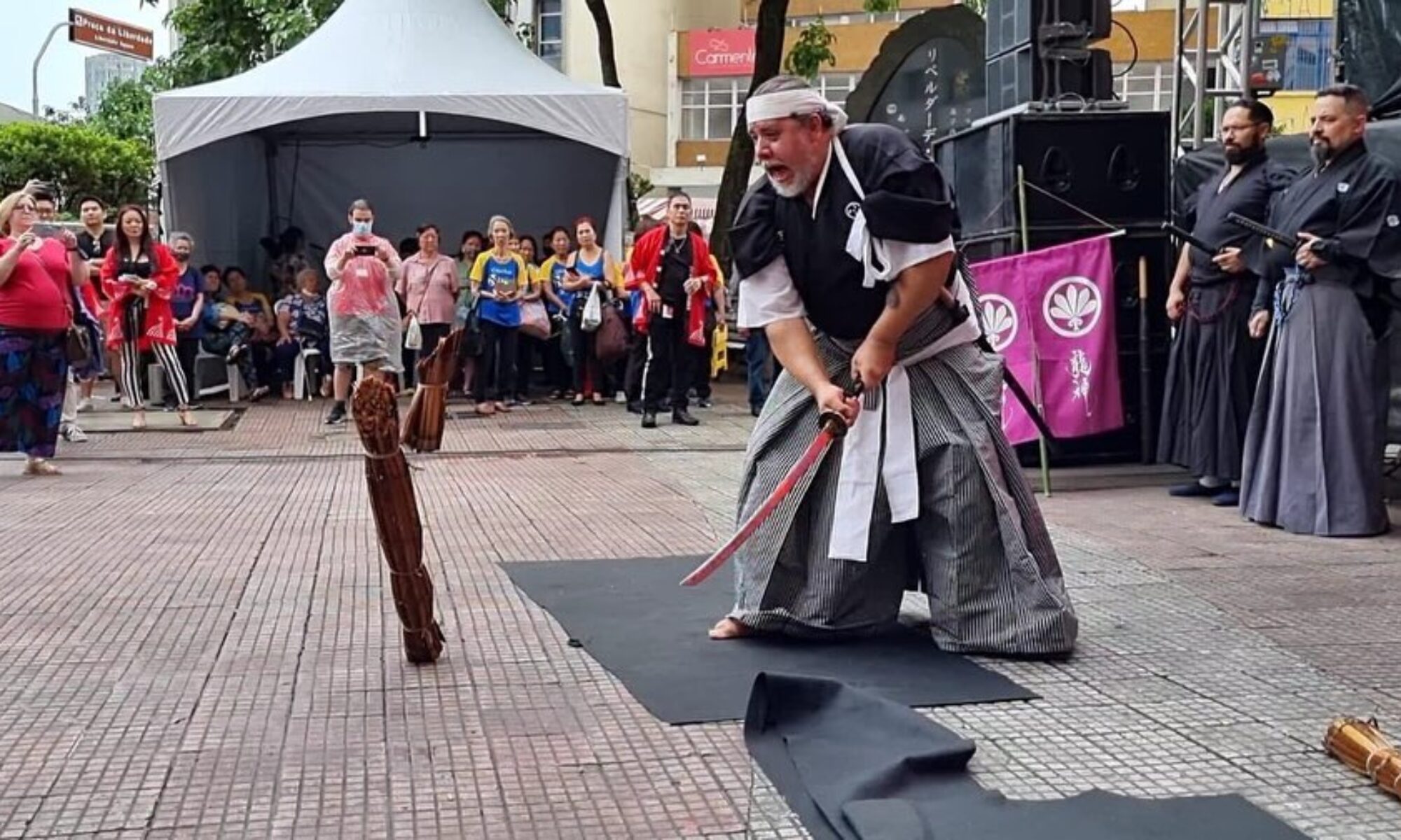 Praticante realizando corte em alvo durante demonstração pública