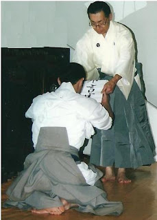Akira Tsukimoto entregando documento a Adriano Pereira